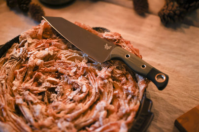 A knife rests on a golden, flaky filo pie dusted with sugar, ready to serve a warm, autumnal dessert.